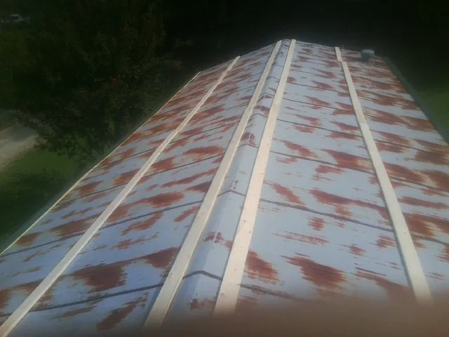 Rusted metal roof panels with new wood purlins before replacement — Storm Damage Roof Repair in Kaw City by Roofing Brothers