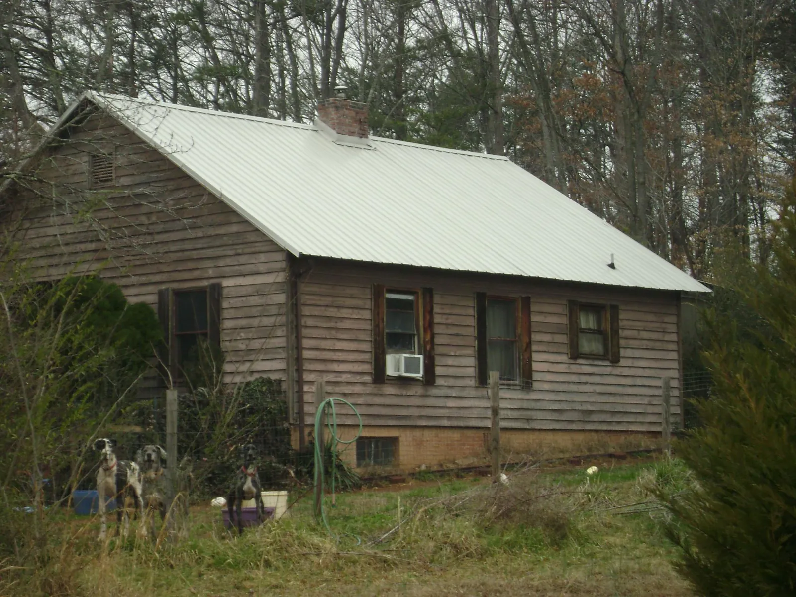 White metal roof on an old wood sided farmhouse, from a Metal Roof Installation job in Kaw City